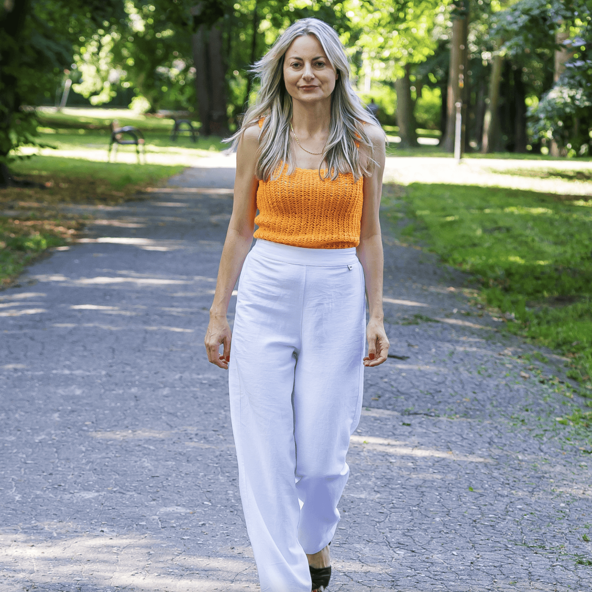 Modelka w białych spodniach konopno-bawełnianych z gumką w pasie, stylizacja letnia.